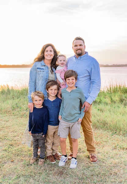 Trey Schnippel with his wife, Maureen, and their four children, smiling together outdoors.